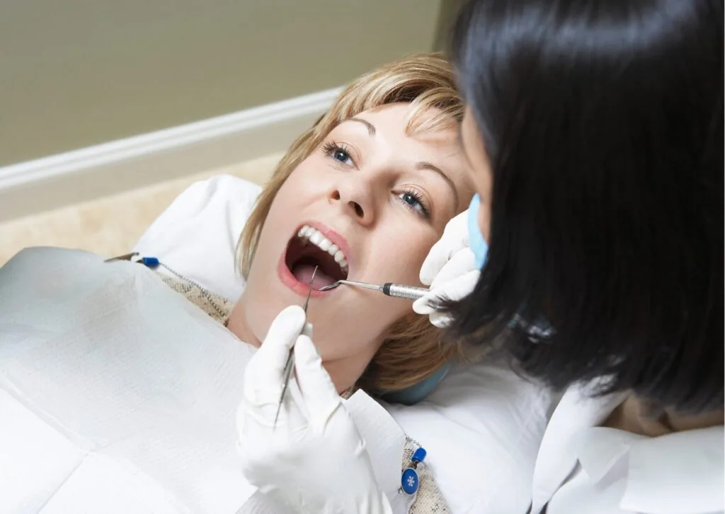 Dentist examining a patient's smile during a cosmetic consultation to determine how many veneers are needed.